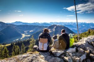 famille avec enfants observant le paysage du hautt d'une montagne