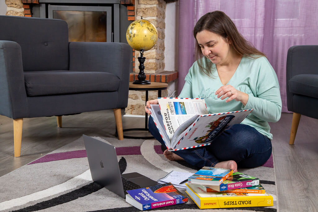 nathalie en train de faire des recherches dans des guides de voyage